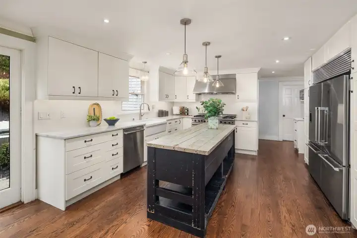 Plenty of room for the whole crew — gather around the reclaimed wood island with drinks while dinner comes together on the professional range nearby