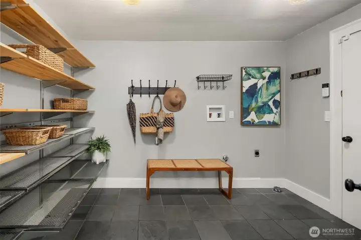 Spacious mud room with tile floors, open shelving, bench seating, and generous storage — perfect for busy households