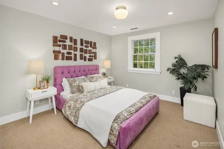 Well-appointed bedroom with plush carpet, recessed lighting, and tree views — a comfortable and versatile space