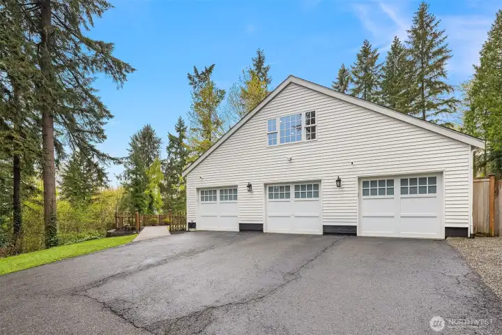 Attached four-car garage with carriage-style doors — room for vehicles, a workshop, or whatever the next chapter calls for
