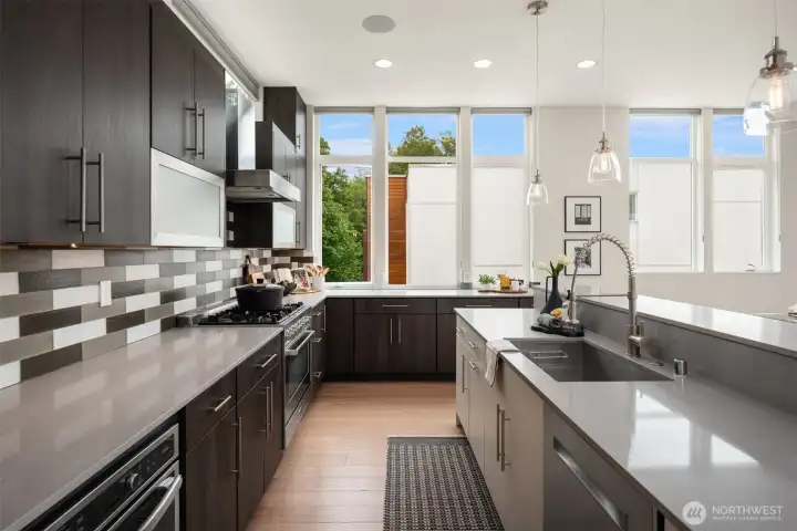 Sleek and highly functional with ample counter space and storage. Gas cooking along with a built-in microwave off to the left.