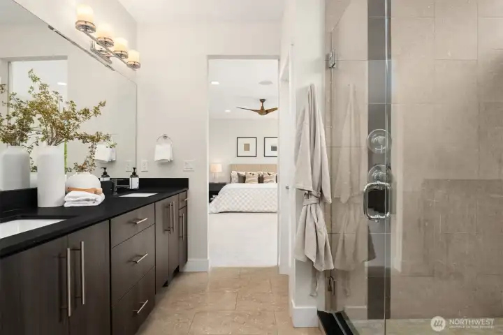 The primary bath has dual vanities with undermount sinks, an abundance of tile and an enormous walk-in shower.