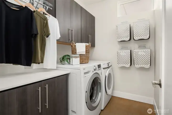 Now this is a laundry room! Full sized front loaders with overhead cabinets, a hanging rack is over the floor cabinets.