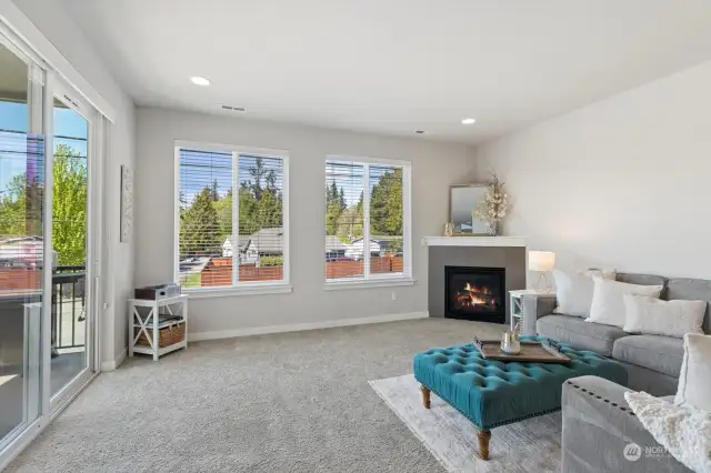 Light and bright living room sits just off of the kitchen and has gas fireplace and patio access for convenient grilling