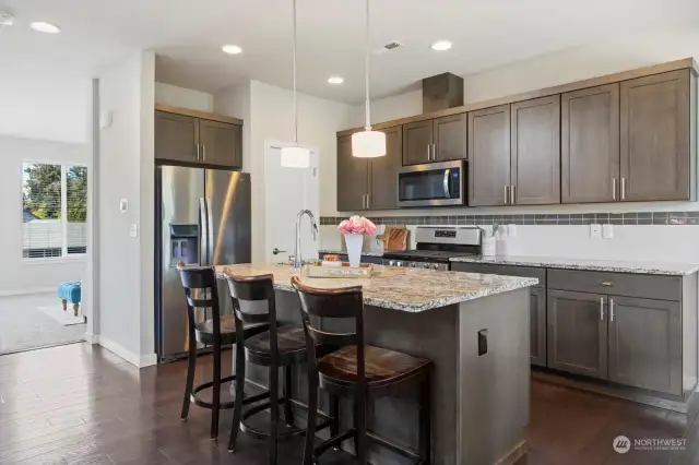 Open concept kitchen has room for bar seating, dining and sitting area. Granite countertops, SS appliances and walk in pantry.