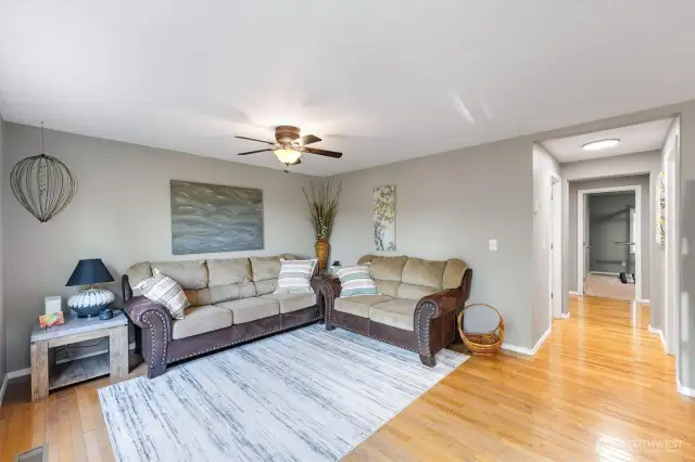 Living Room w/ Ceiling Fan & Hardwood Floors.