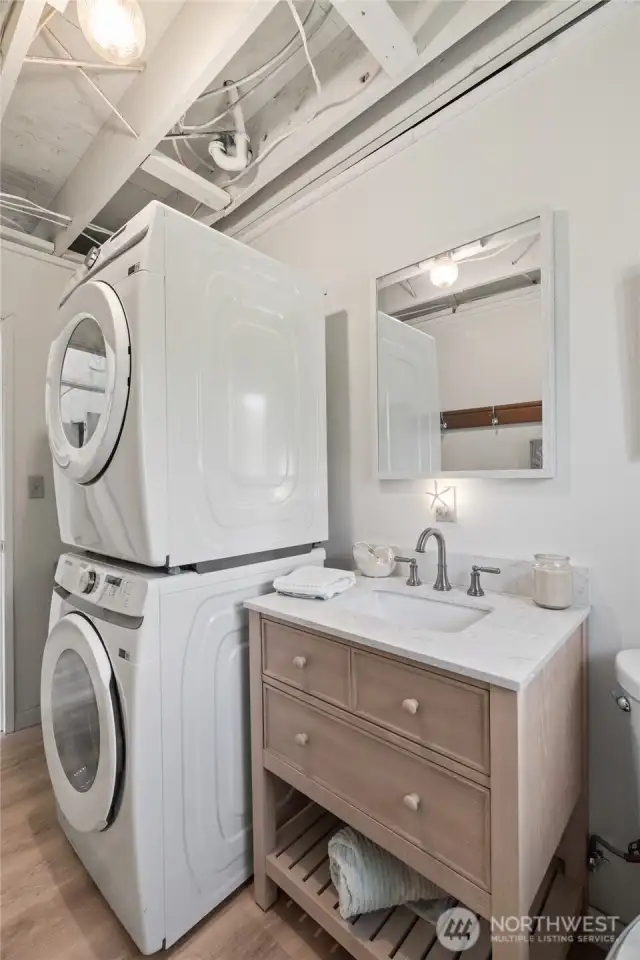 Stacked laundry machines in half bath