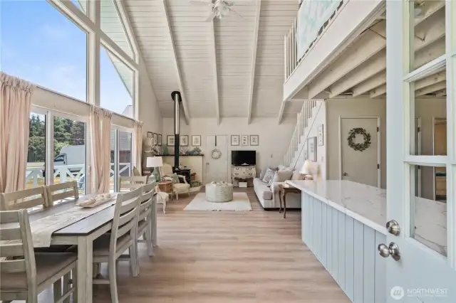 Open concept with super high vaulted ceiling, floor to ceiling windows & sliders to deck on East side