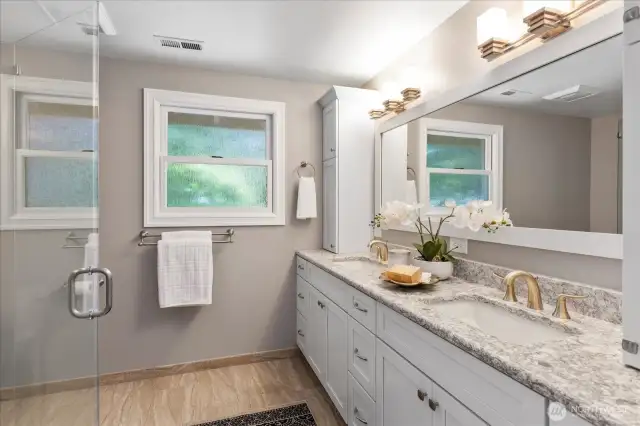 Spa styled bath features heated tile floors, solid surface counter tops and double sinks.