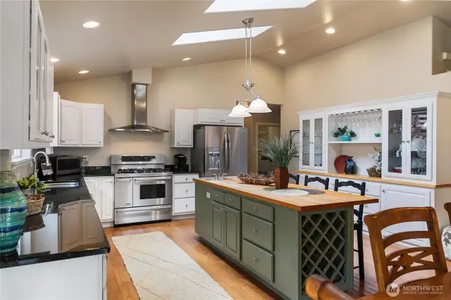 Kitchen is complemented by stainless steel appliances, granite countertops, and generous walkways for easy movement.