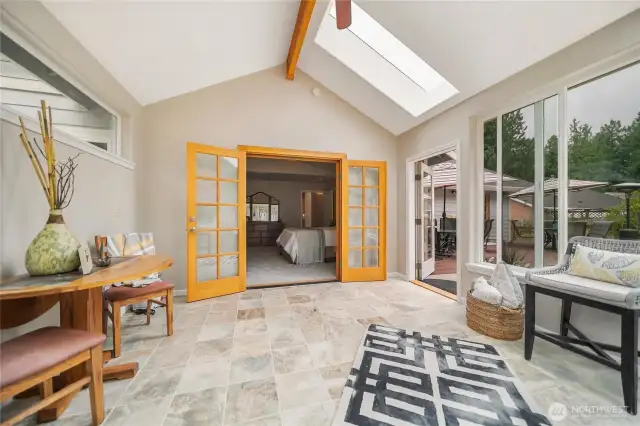 French doors provide a view into the primary bedroom, while the door to the right offers direct access to the spacious backyard.