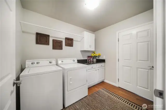 Elegant hardwood floors extend into the laundry room, which provides convenient access to the oversized two-car garage.
