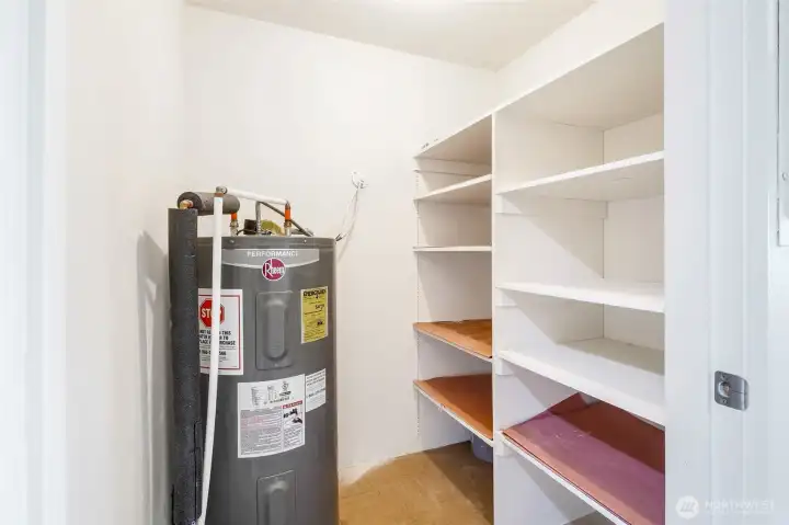 Utility closet with hot water tank and shelving.