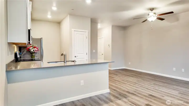 Bright main living space with recessed lighting and seamless flow from kitchen to living area.