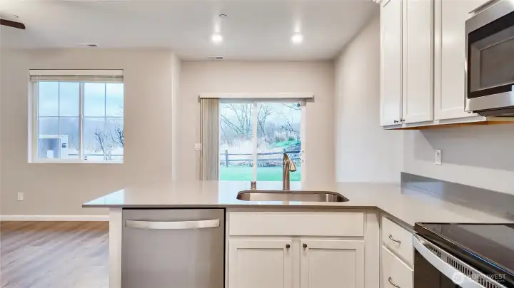 Kitchen with stainless appliances and sliding door access to the backyard.