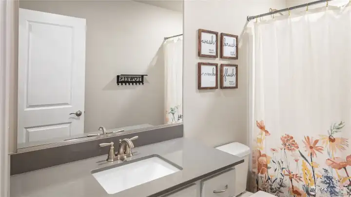 Hallway bathroom with single vanity and tub shower combination.