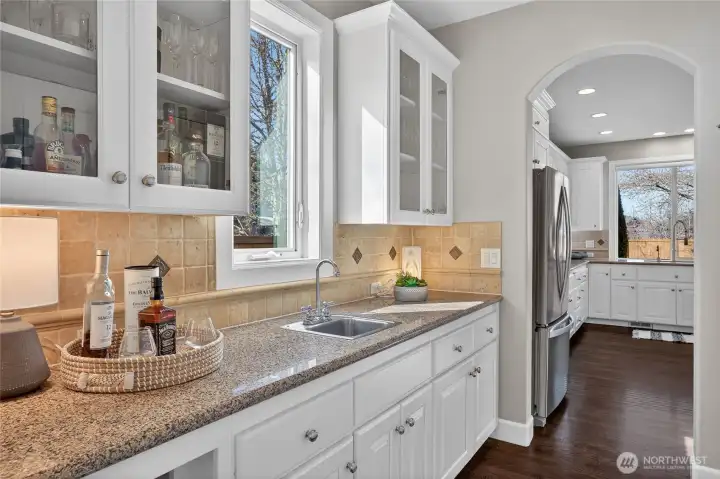 Convenient wet butler's bar adds extra pantry space as well as a passthrough between the dining room and kitchen.