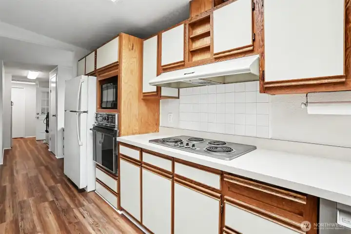 Spacious gourmet kitchen features new LVP flooring, skylights, wall oven, cooktop, western exposure and eating bar opening to the family room.