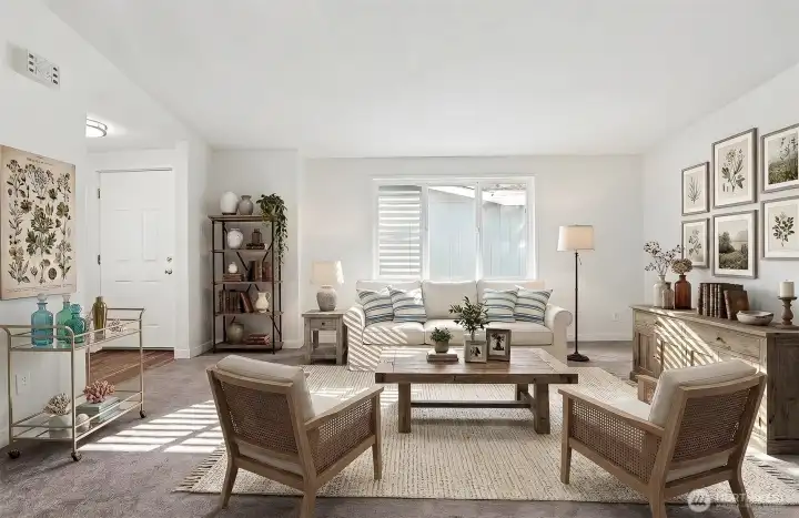 Formal living room with vaulted ceilings opens to the formal dining room.   Front entry way is on the left side.  Virtually staged photo.