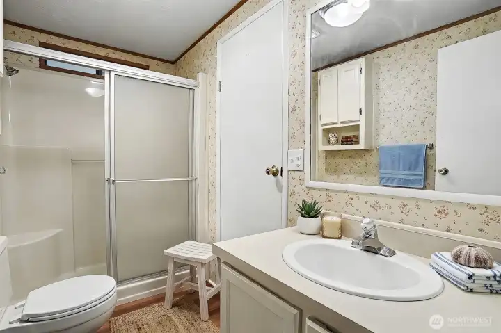 2nd full bathroom with a walk in shower and new LVP flooring.  Virtually staged photo.
