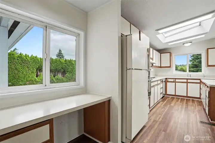 Laundry room/bonus room with a built in desk has new LVP flooring and paint.   Washer and Dryer included and also has a utility sink