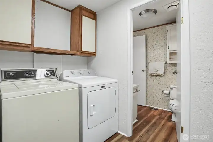 Laundry room/bonus room with a built in desk has new LVP flooring and paint.   Washer and Dryer included and also has a utility sink