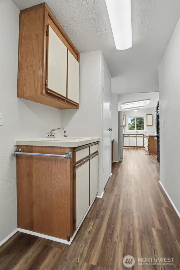 Laundry room/bonus room with a built in desk has new LVP flooring and paint.   Washer and Dryer included and also has a utility sink
