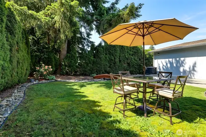 Private back yard with a patio and garden space.  Virtually staged photo.