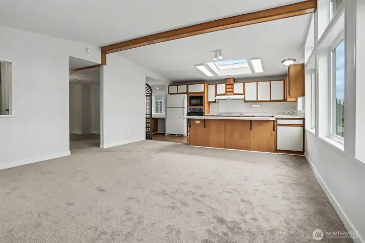 Family room features vaulted ceilings, wall of double pane updated windows with light and bright western exposure and new wall to wall carpet.  Opens to kitchen with an eating bar and skylight.  New wall to wall carpet and interior paint