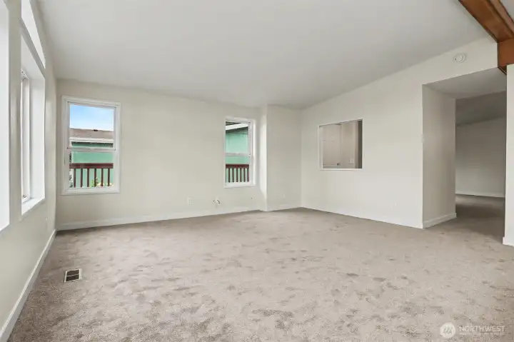 Family room features vaulted ceilings, wall of double pane updated windows with light and bright western exposure and new wall to wall carpet.  Opens to kitchen with an eating bar and skylight.  New wall to wall carpet and interior paint