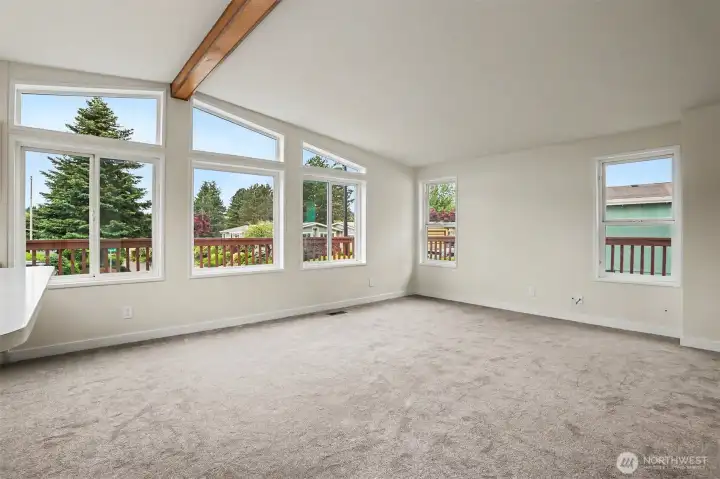 Family room features vaulted ceilings, wall of double pane updated windows with light and bright western exposure and new wall to wall carpet.  Opens to kitchen with an eating bar and skylight.  New wall to wall carpet and interior paint