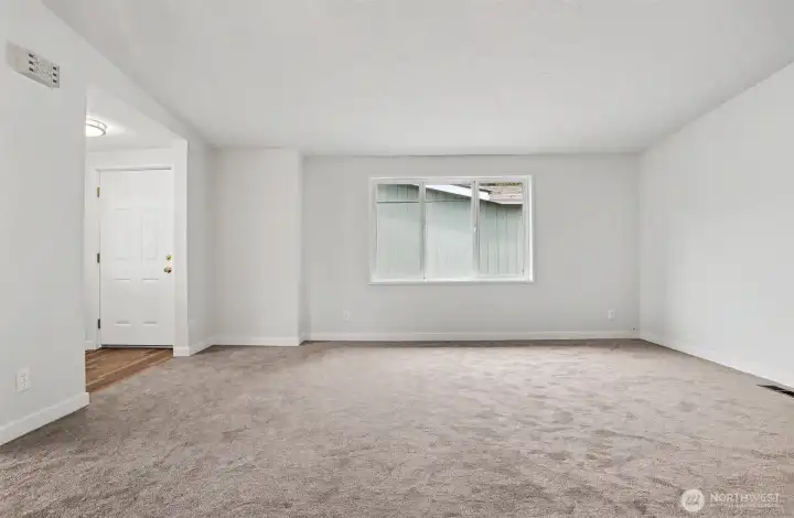 ormal living room with vaulted ceilings opens to the formal dining room.   Front entry way is on the left side.  New wall to wall carpet and interior paint.