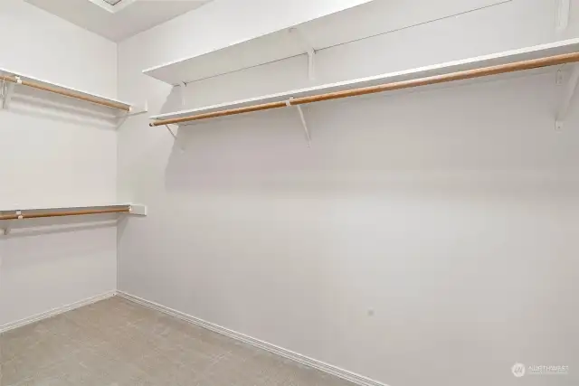 Plenty of space for all your clothes in this primary closet. Shelving and different levels of racks will make organizing your clothing and shoes collection a breeze.