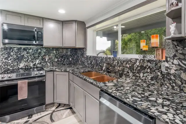 Custom brass sink makes cleaning up pleasurable as you enjoy the nature outside the window