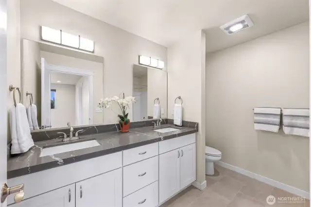 Primary bathroom with double vanity and granite countertops