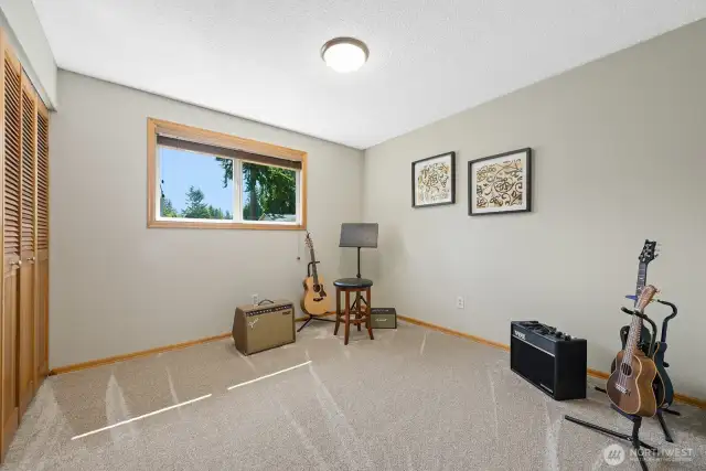 3rd main floor bedroom, currently staged as music room, located on east side of home.