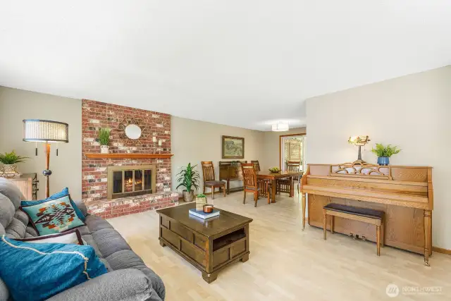 Expansive living room with wood burning fireplace, laminate flooring and updated lighting. Newly repainted!