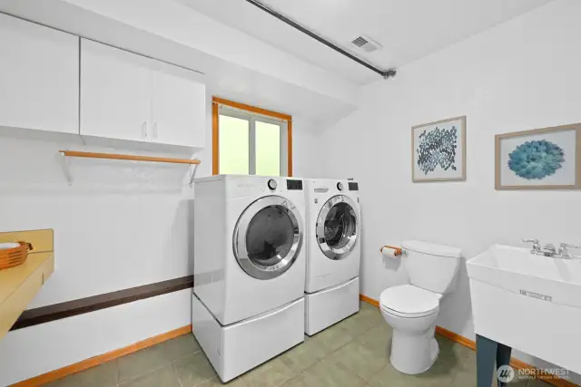 Full sized laundry room offers folding table, extra drying rack, half bath and extra storage.