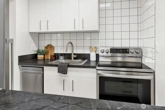 Kitchen with custom cabinets, modern tile work and new appliances