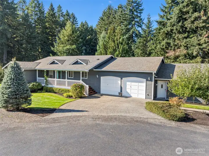 Front elevation of home with fully covered front porch and established apple trees.