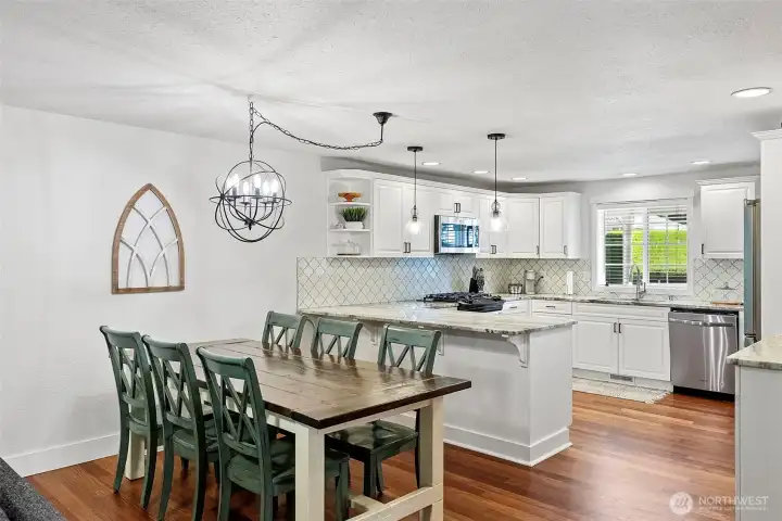 Kitchen with dining space where refinished hardwood flooring makes the main level flow from space to space.
