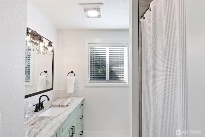 Main level full bathroom with beautifully refinished shower/tub combo.