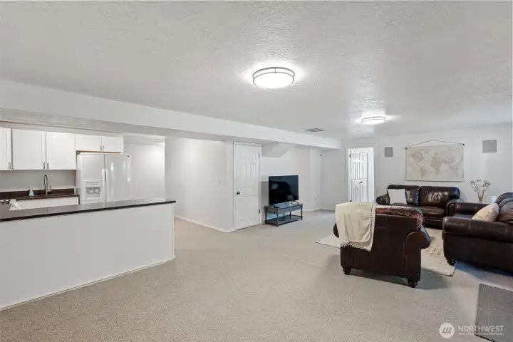 Lower level open concept living space with kitchen, eating area, and family room.