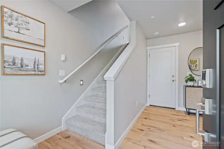 Large entry with laminate flooring hosts the 4th bedroom, full bath and garage entry. Photos are of model home in the community.