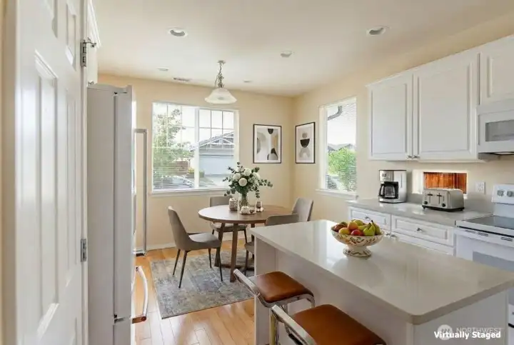 Bright white kitchen has Siltstone counter tops and loads of storage.