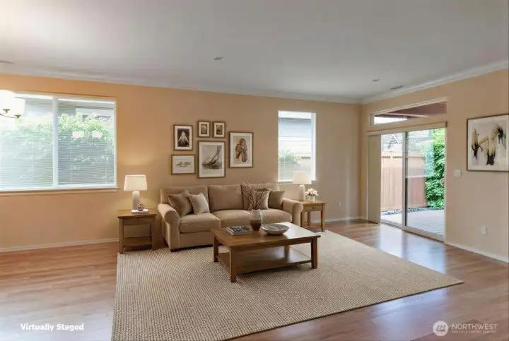 Another view of the living room.  Notice the large windows that let in lots of natural light.  The slider leads to a covered deck that steps down into an expanded paved area.