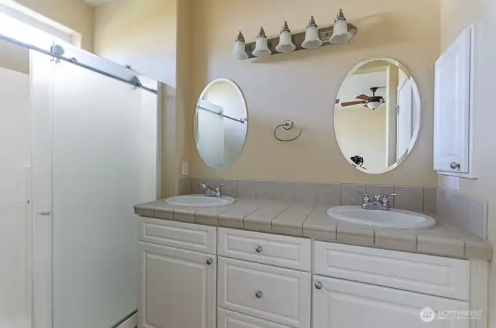 Primary bath has double sinks and separate toilet area.
