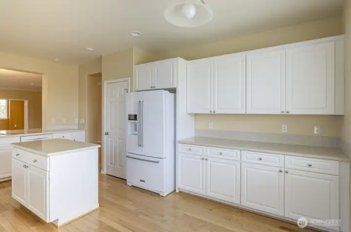 View of the kitchen from the casual dining area.  Added cabinetry offers so much storage and more counter space.