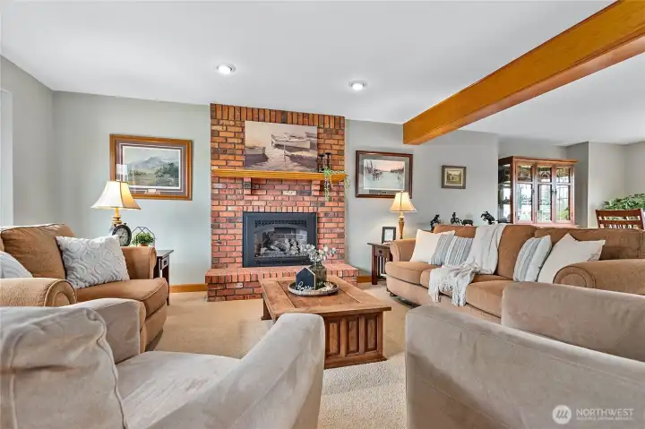 Cozy living room just off foyer with brick-surround gas fireplace