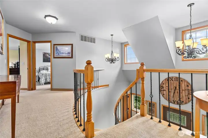 Heading upstairs - open and bright 2 story landing. Owner's suite through door on left